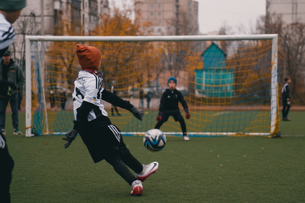 Children playing soccer on a cool autumn day in a park in Kyiv, Ukraine, enjoying outdoor sports.